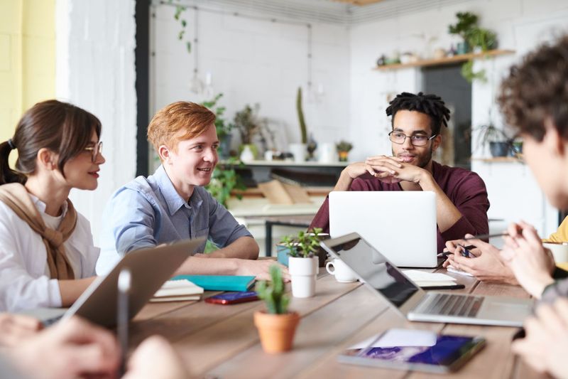 Employer team discussing staffing questions with a recruiter at a meeting table