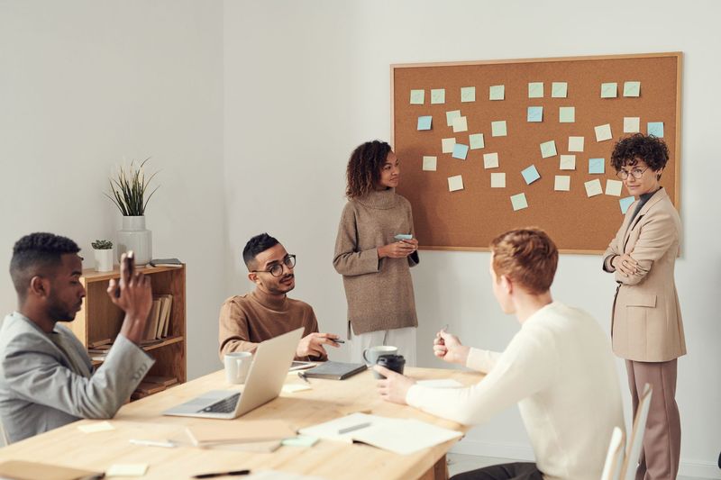 Recruiters planning a sourcing strategy at a pinboard with a client team