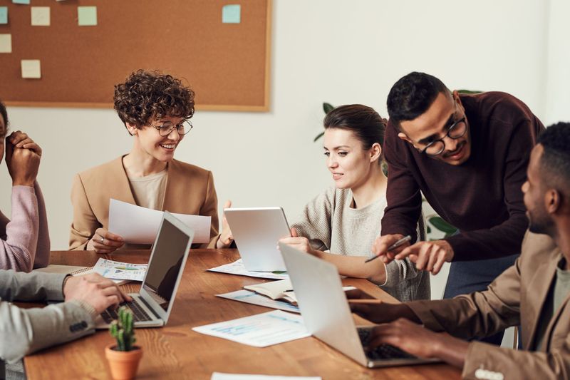 Professional support staff working together over laptops in a corporate office