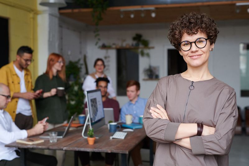 Recruitment consultant standing in the office while the team works behind her