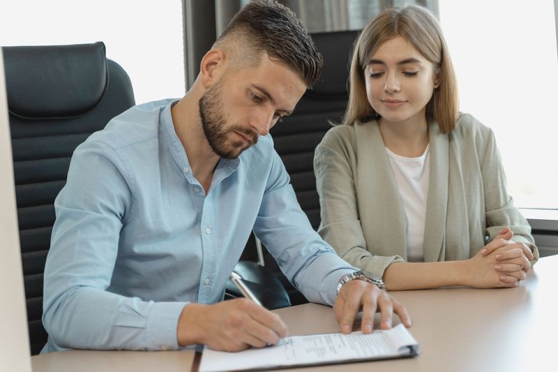 Manager and temp-to-hire employee reviewing progress together at a desk
